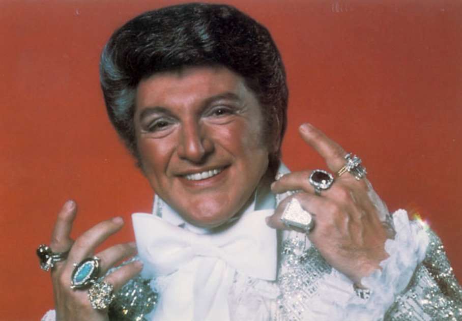 Liberace wearing his famous rings